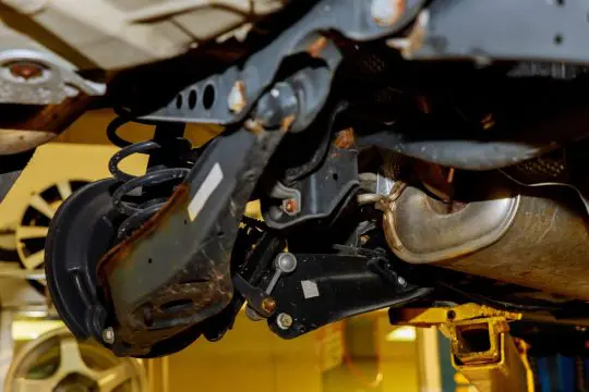 underside view of a vehicle showing the suspension and brakes with the wheel removedBrakes on a car with removed wheel Brakes and suspension underside view of a vehicle showing the suspension and brakes with the wheel removed