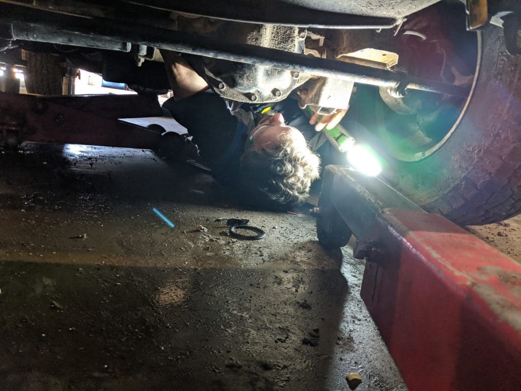 Belly Brothers Auto Tech working under a vehicle