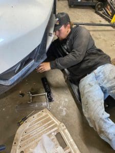 Belly Brother auto tech working on the front end of a vehicle