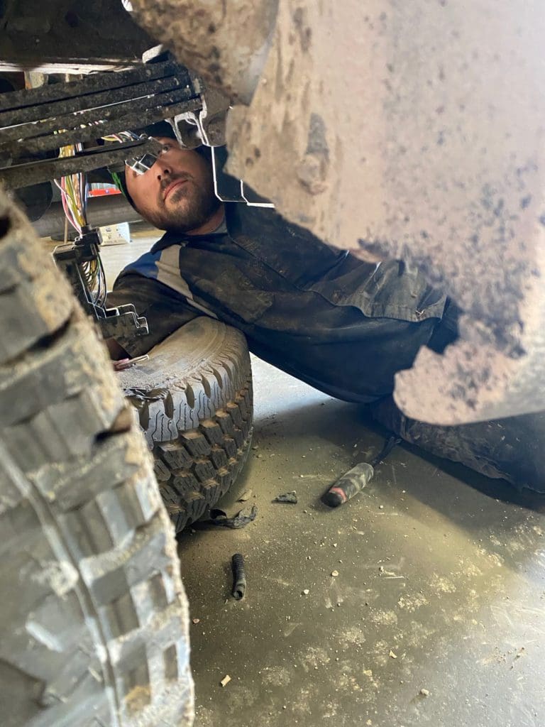 Belly Brother auto tech working on the underside of a vehicle