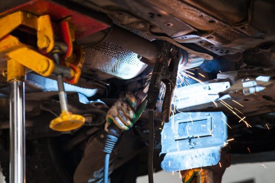 welder welds silencer on exhaust pipe welder welds silencer on exhaust pipe